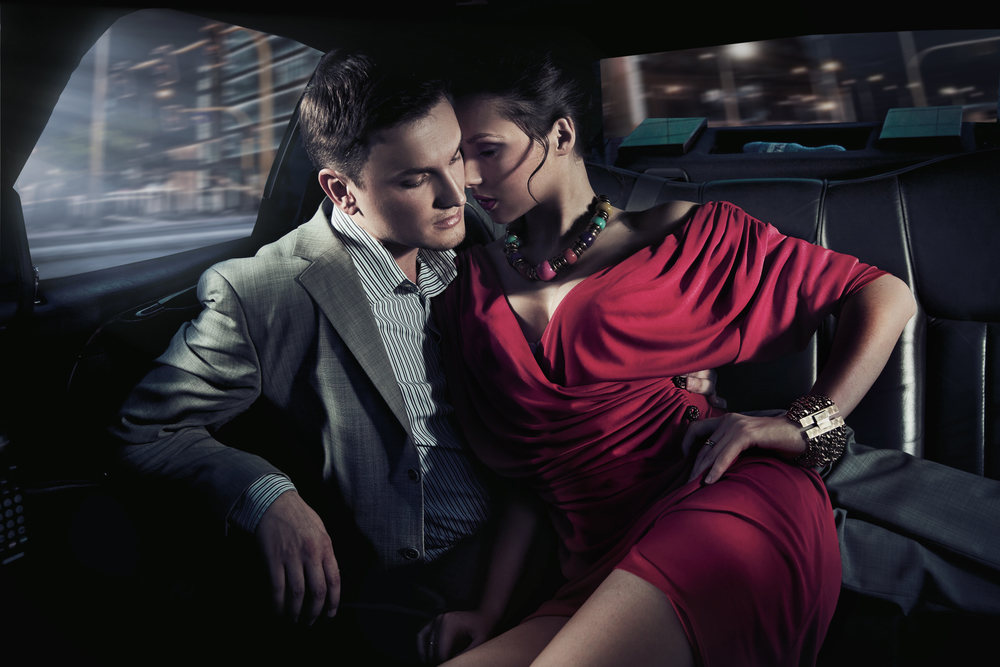 Pareja sexy sentada en el coche