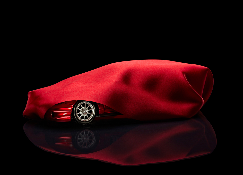 new car hidden under red cover