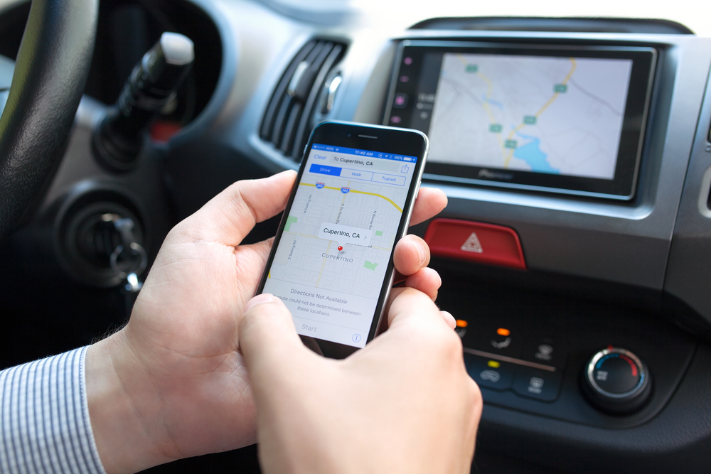 Man holding iPhone 6 with Apple Maps and Car Play