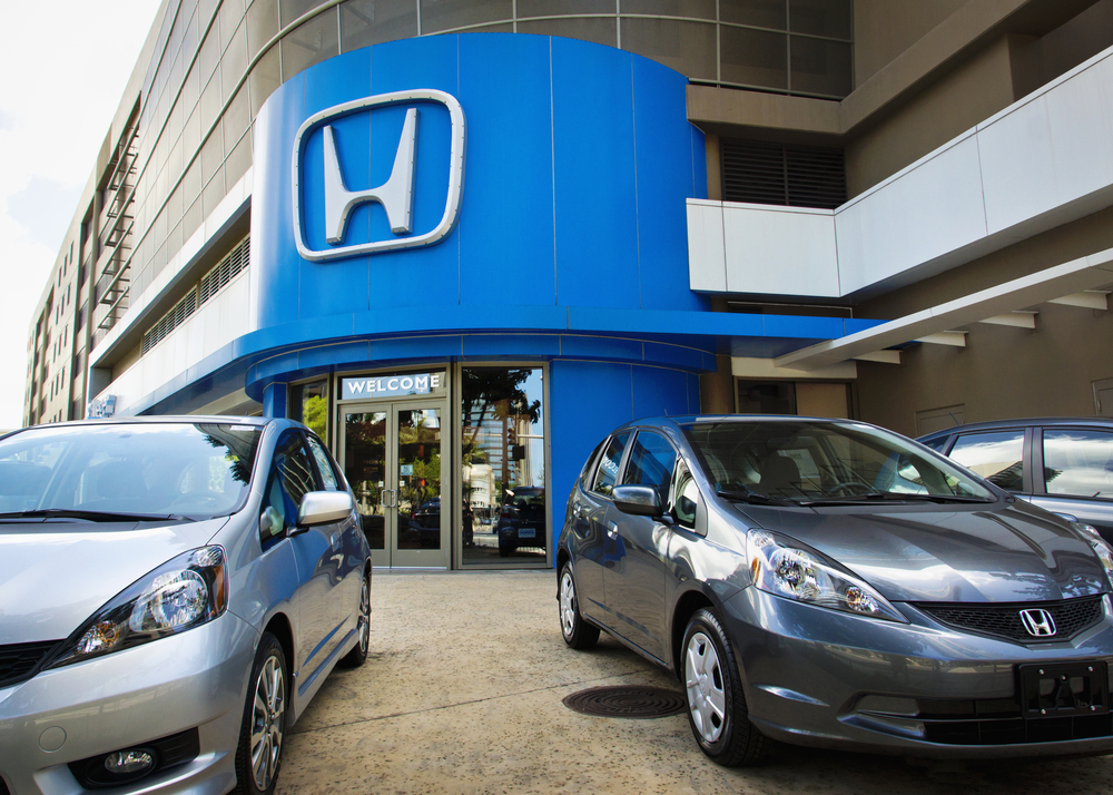 honda cars parked in front of a dealership in a downtown setting.