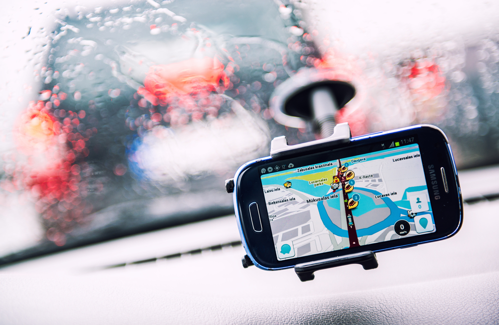 Smart phone with a Waze GPS navigator on the screen. Waze is one of the world's largest community-based traffic and navigation apps