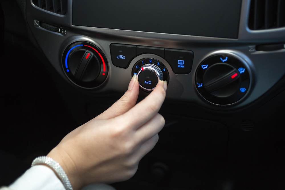 Woman turning on car air conditioning