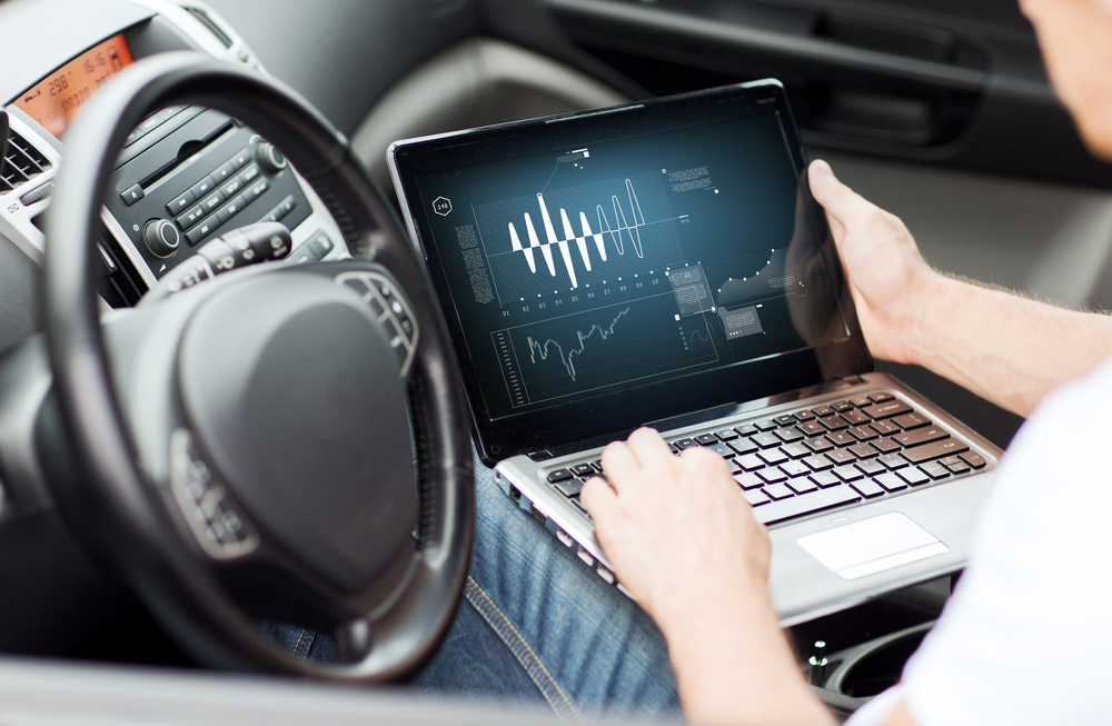 man using laptop computer in car