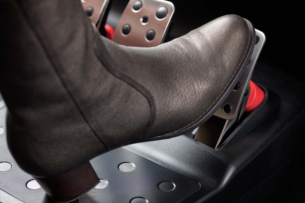 Woman pressing the gas pedal with her foot. Close up.