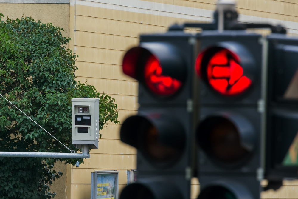 the red light of a traffic signal is monitored by a red light camera.