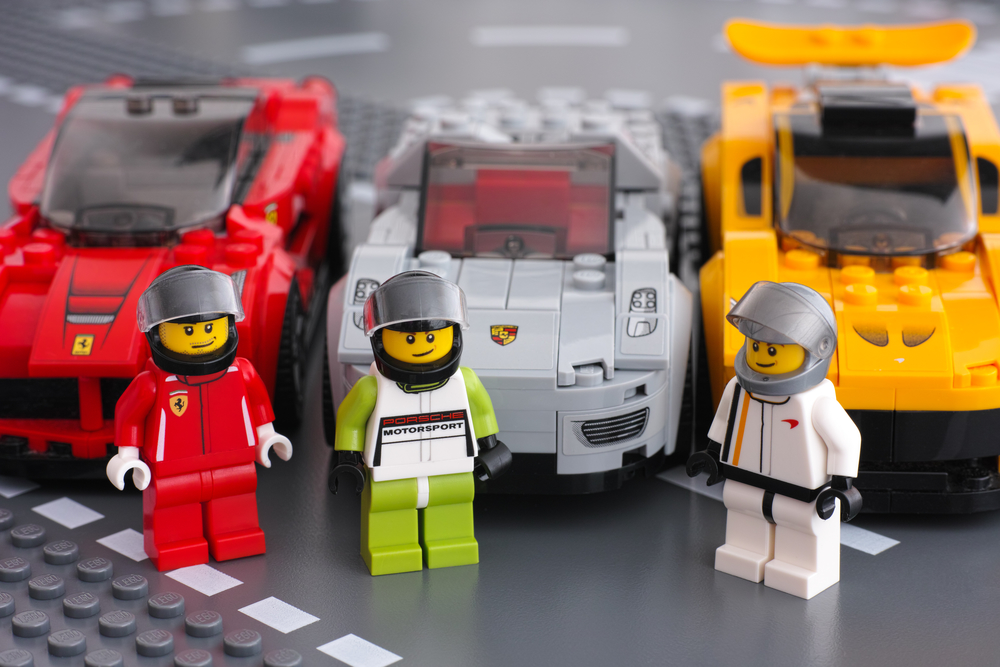 2015 Lego drivers minifigures by LEGO Speed Champions and his car on background. There are Lego LaFerrari, Lego Porsche 918 Spyder and Lego McLaren P1 cars. Studio shot.