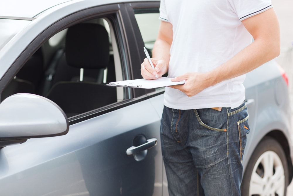 man-inspecting-vehicle-min