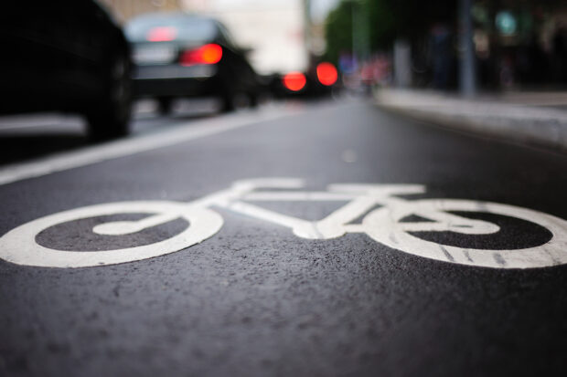 A close up image of a bike lane on a busy city street.