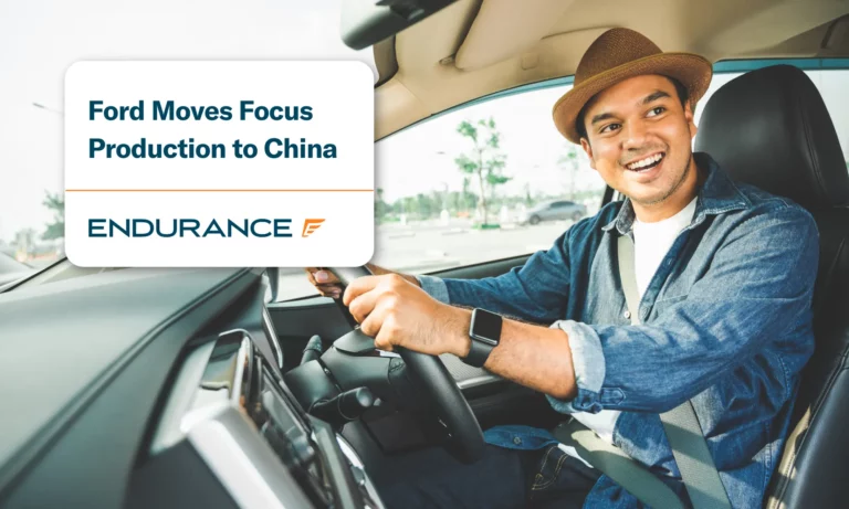 Man with a hat on driving a Ford car