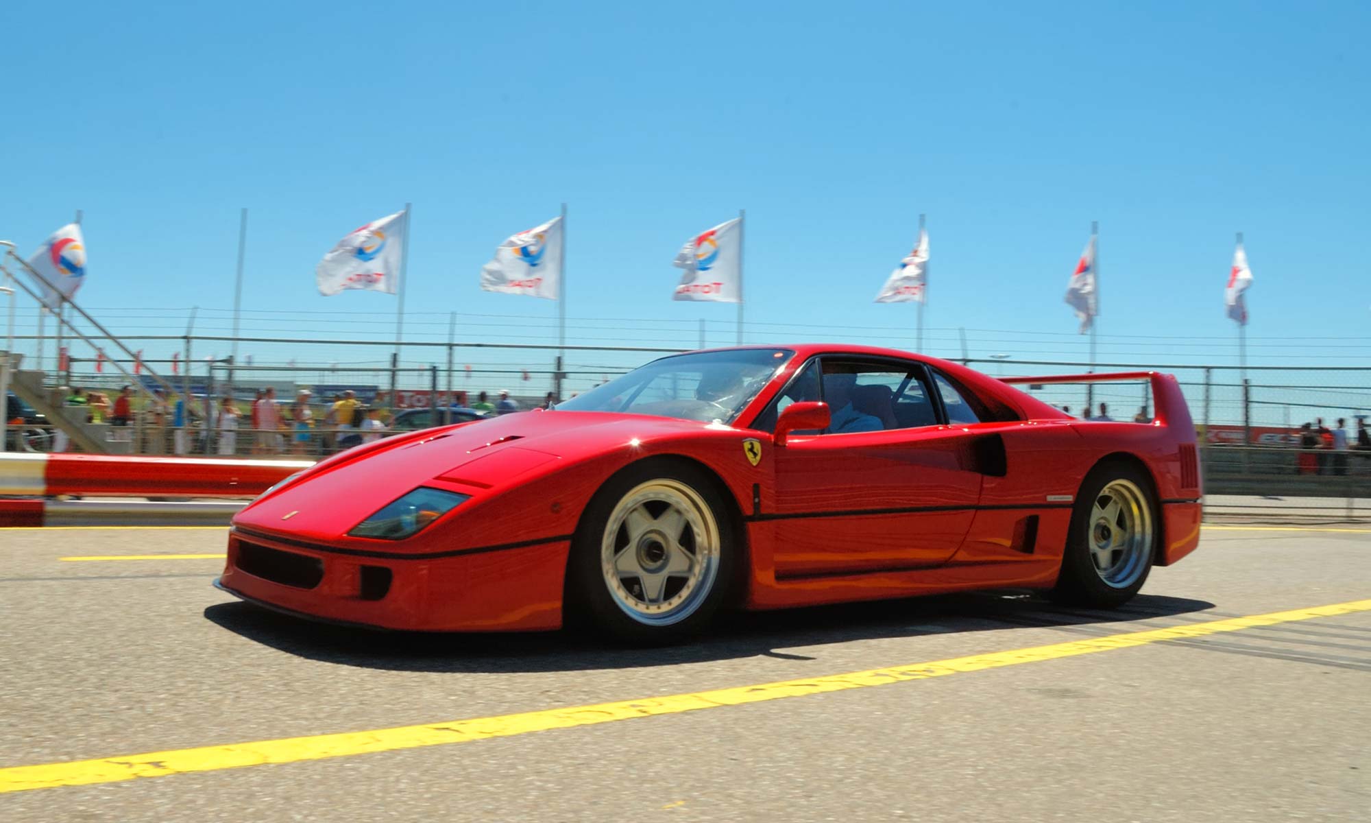 A red Ferrari F40 driving around a race track.