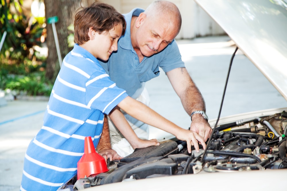 gransfather and son fixing a car together