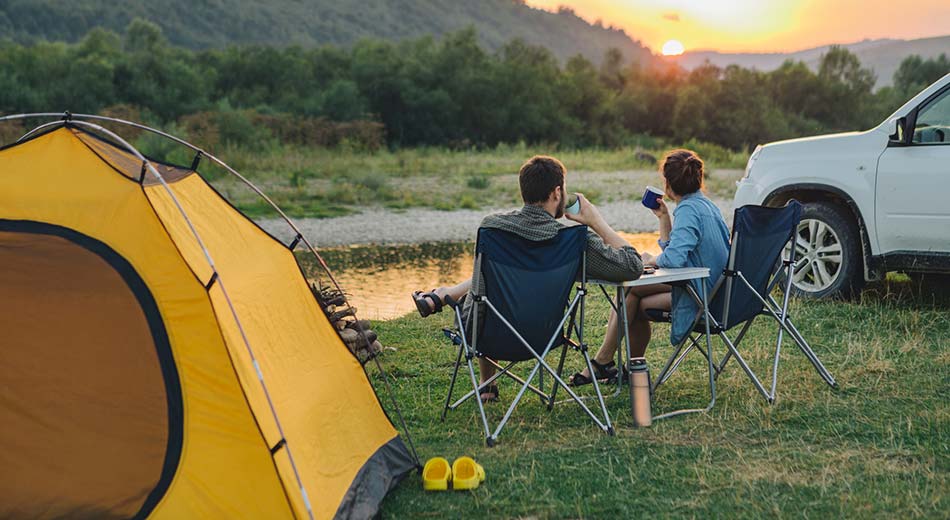 A couple sitting on camping chairs.