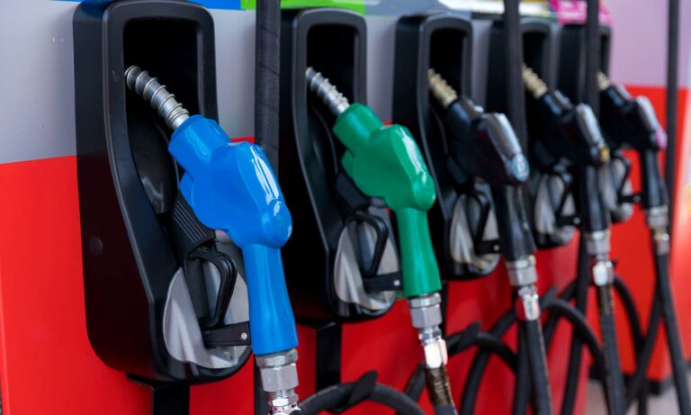 A row of 5 gas nozzles at a gas station.