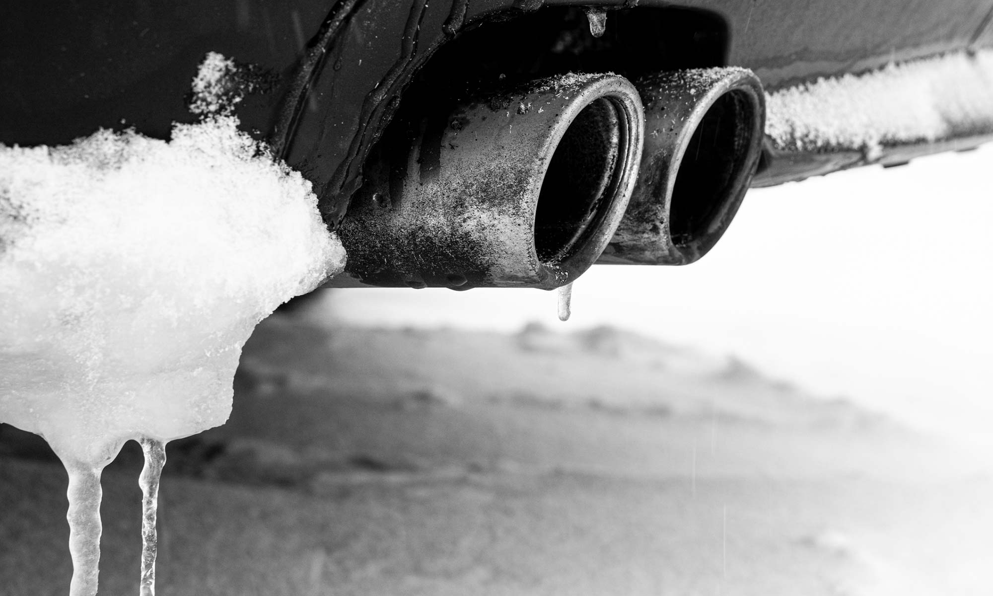 A vehicle's exhaust pipe covered in snow.