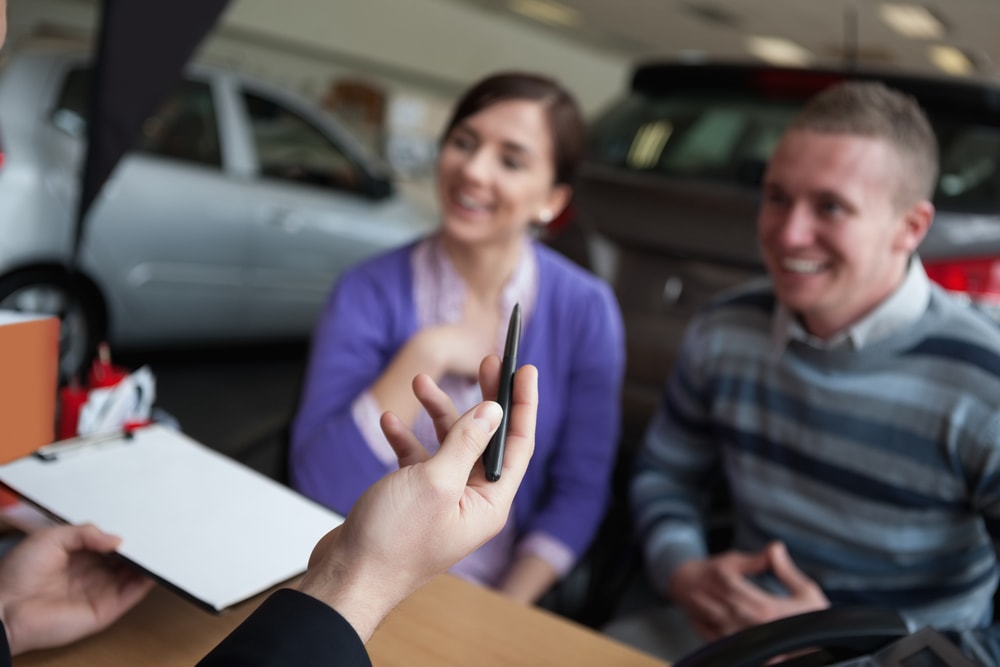 couple listening to car dealer