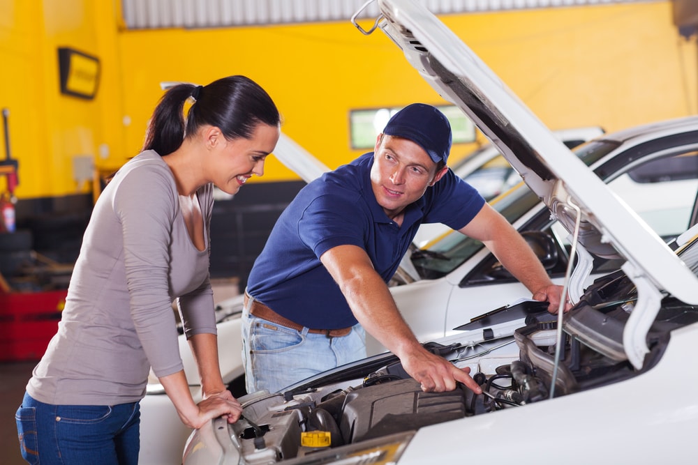 mechanic showing a customer the car problem