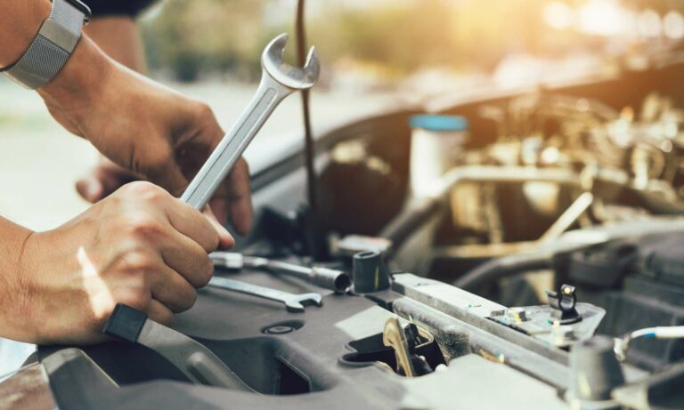 A car mechanic using a wrench.