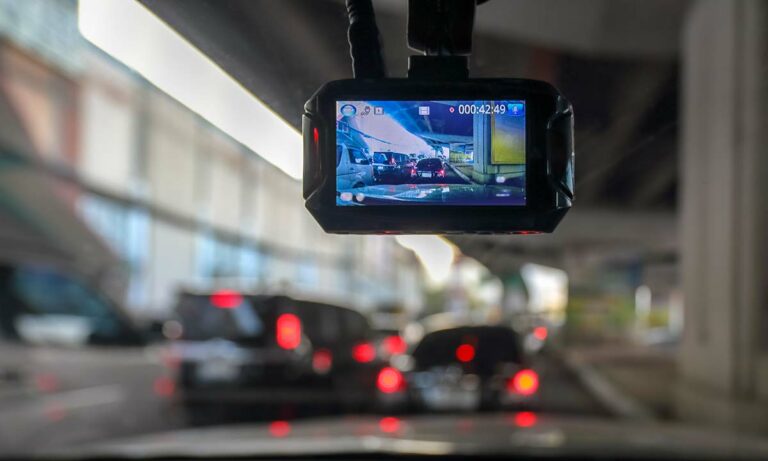 A dash cam mounted on a car's windshield.