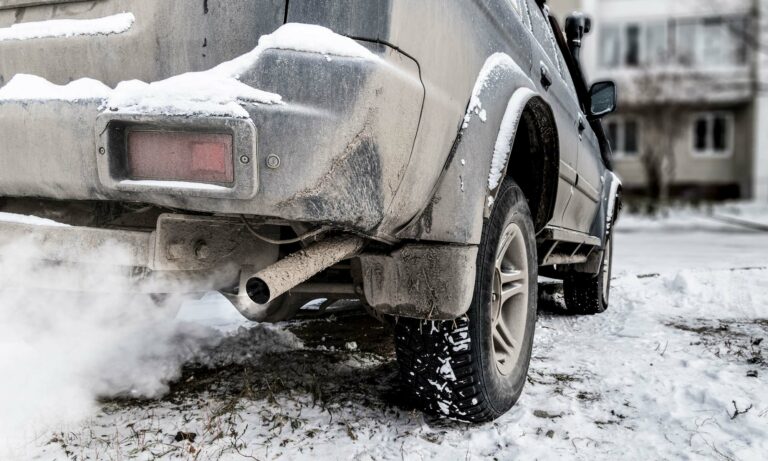 A car idling in a driveway covered in snow.