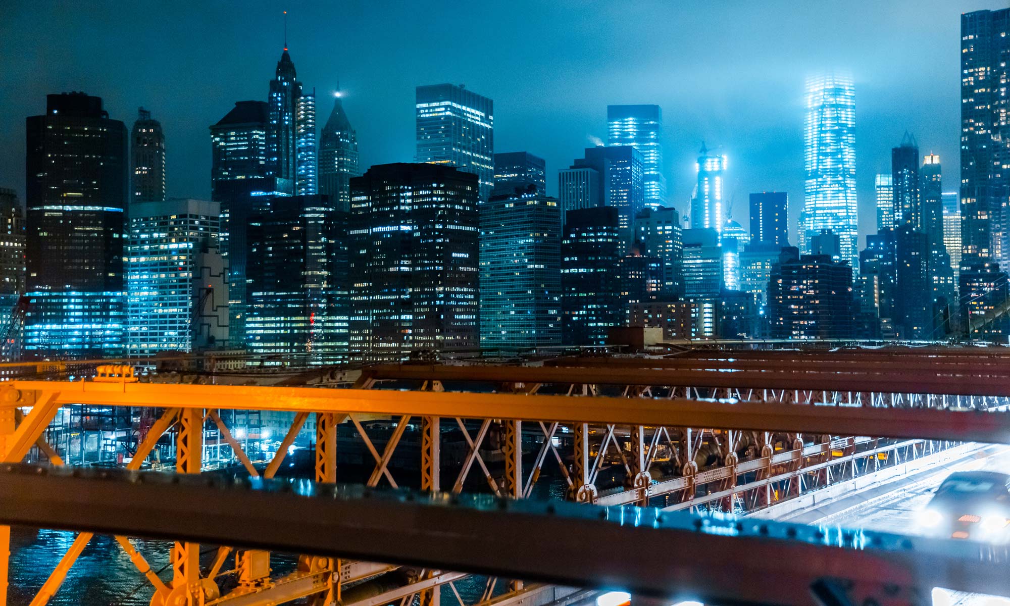 A car drives across a bridge at night in 