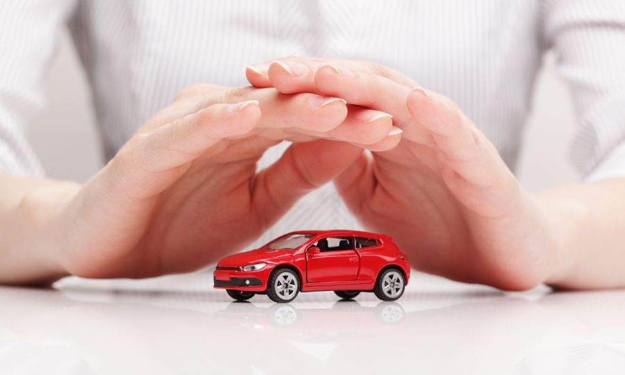 Hands creating protective shield over small car