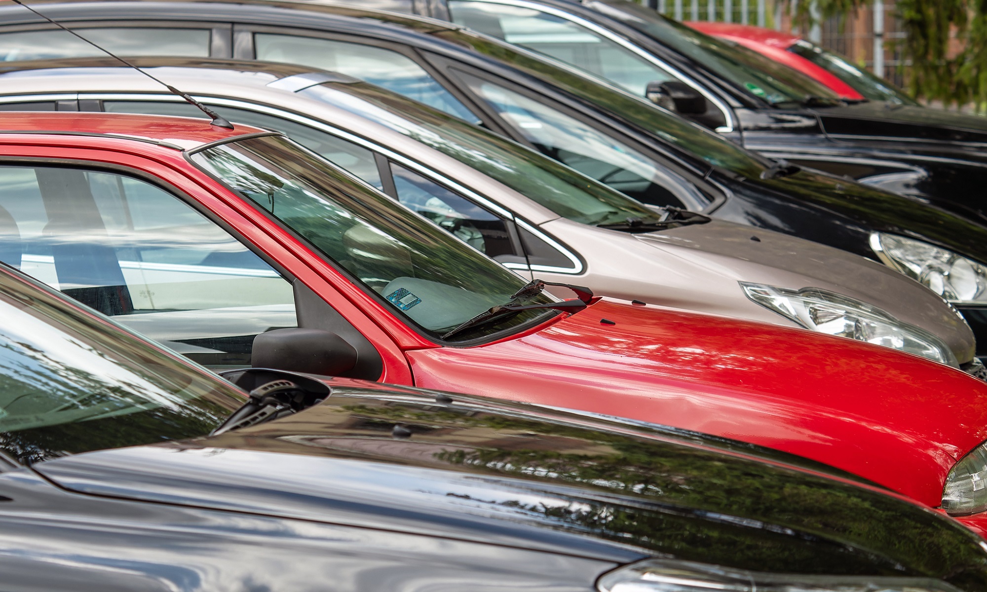 used cars in a lot, red used car, black used car