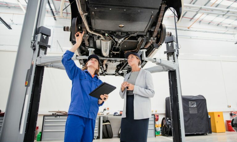 Mecánica discutiendo costosas reparaciones de automóviles con su gerente