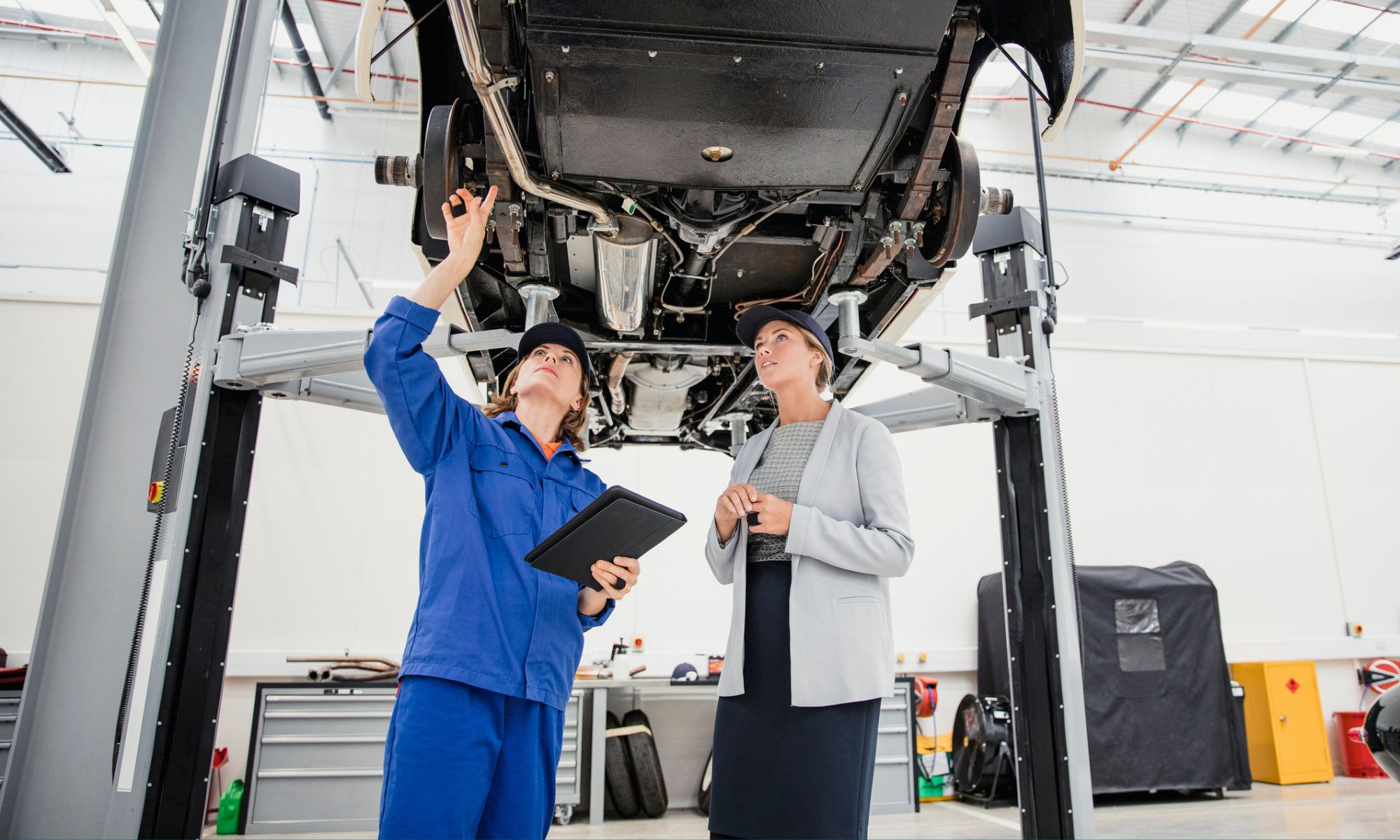 Mechanic discussing expensive car repairs with her manager