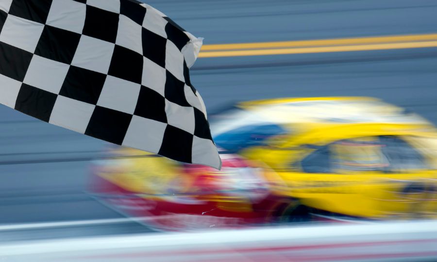 Checkered finish line flag at a car race, yellow car