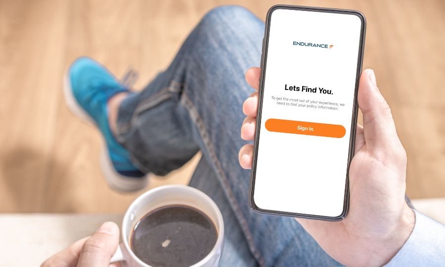 Man with coffee looking at the Endurance mobile app on his phone