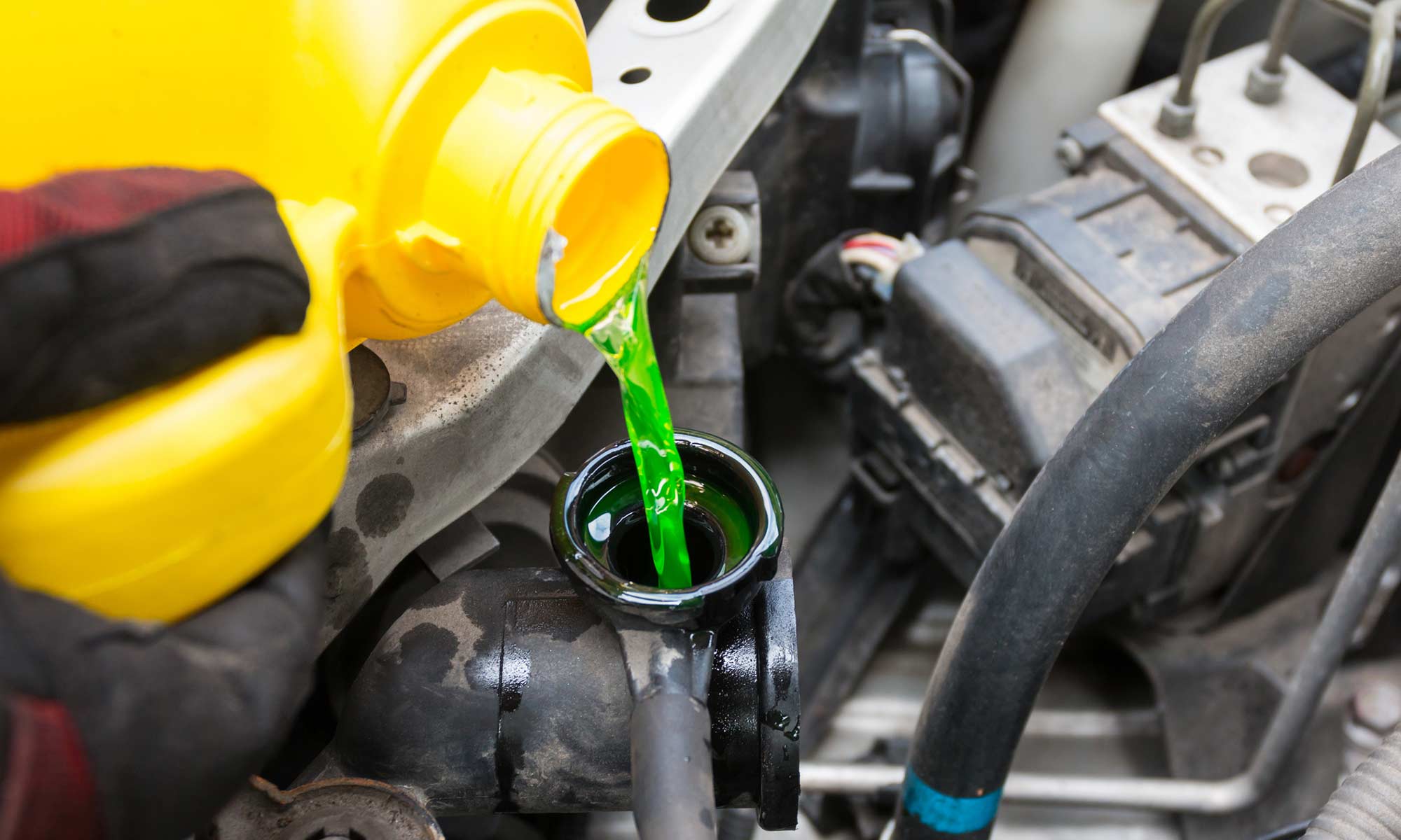 A person changing their vehicle's coolant.