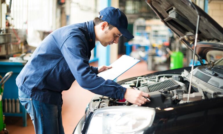 A car mechanic checks the air filter of a vehicle, which can be covered in your very own Endurance auto protection plan.