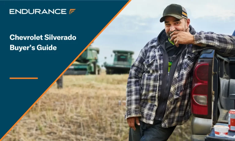 Man standing by his Chevy pickup truck on a farm