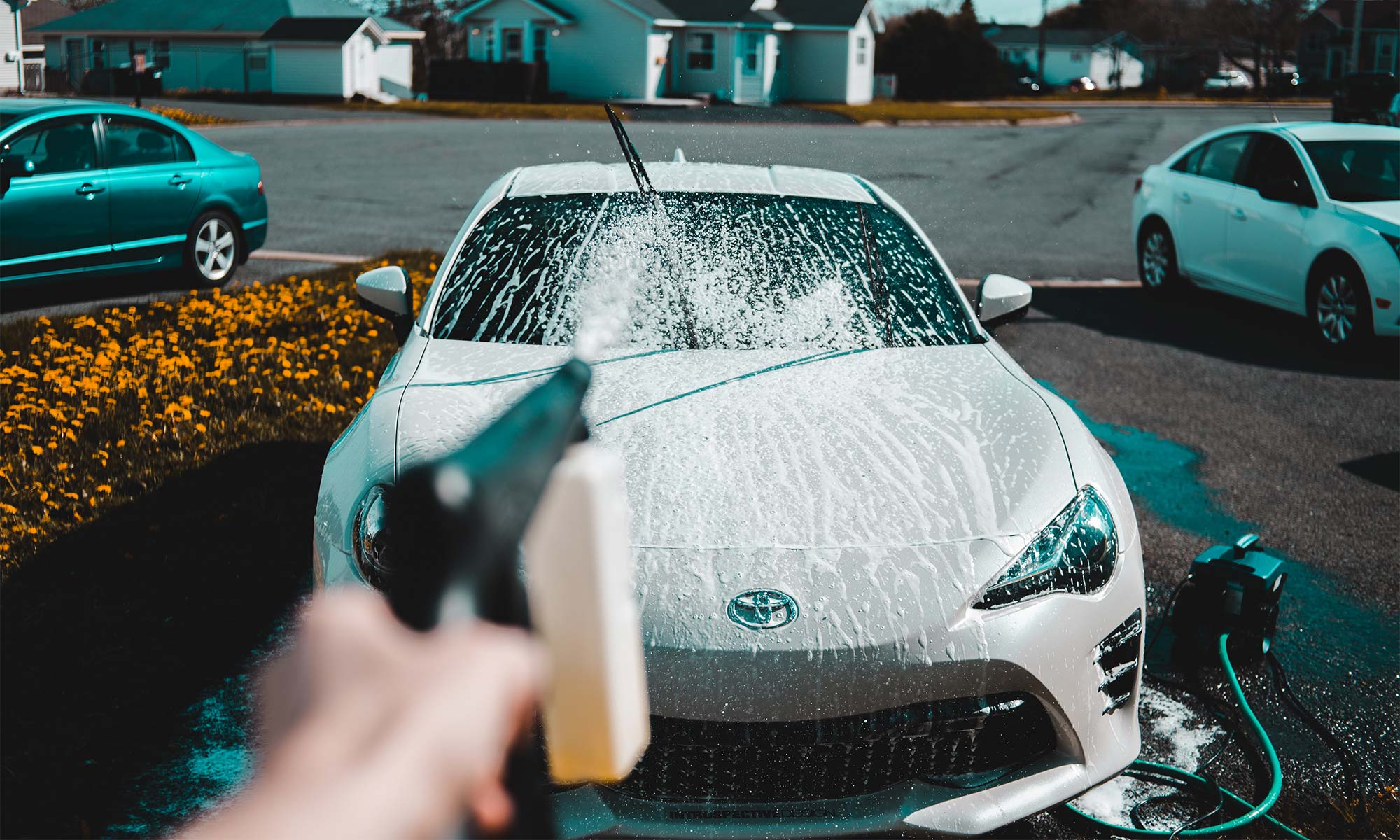 Washing a car in the driveway.