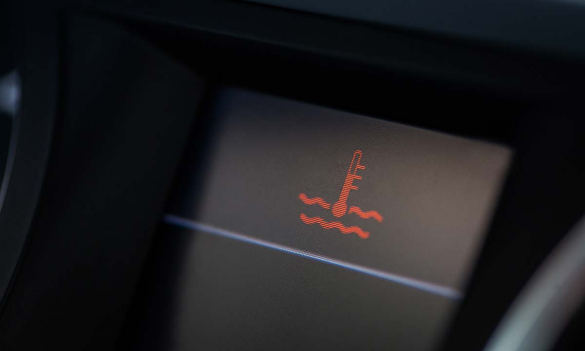 An image of the red thermometer warning indicator on a vehicle dashboard display, indicating possible engine overheating. 