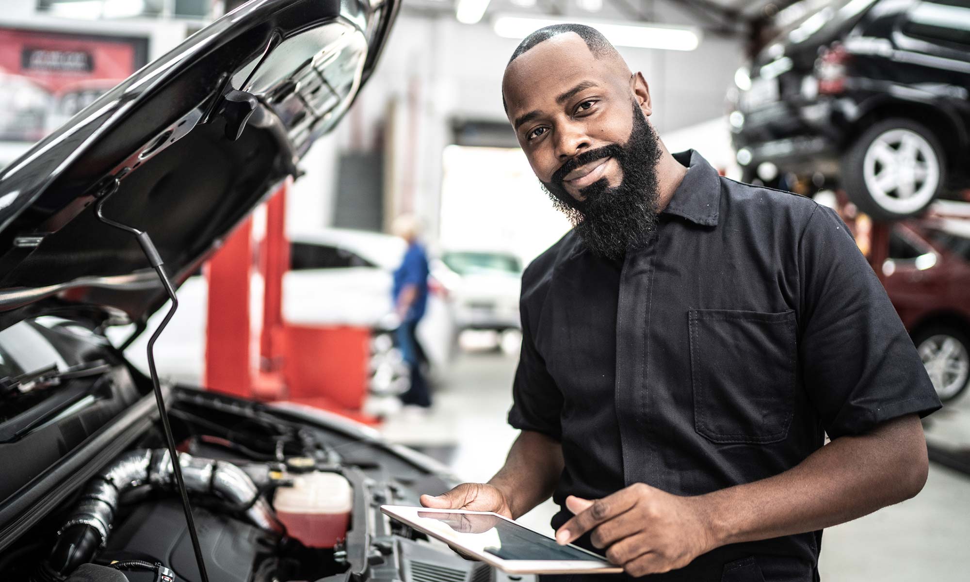 A mechanic in front of a car.