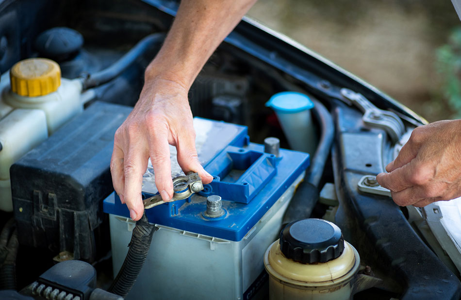 A man reconnects his vehicle's battery.