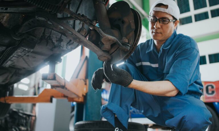 A vehicle mechanic working on a car.