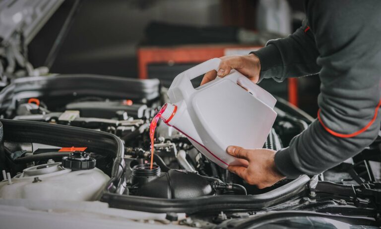 A mechanic pouring antifreeze into a vehicle's engine.