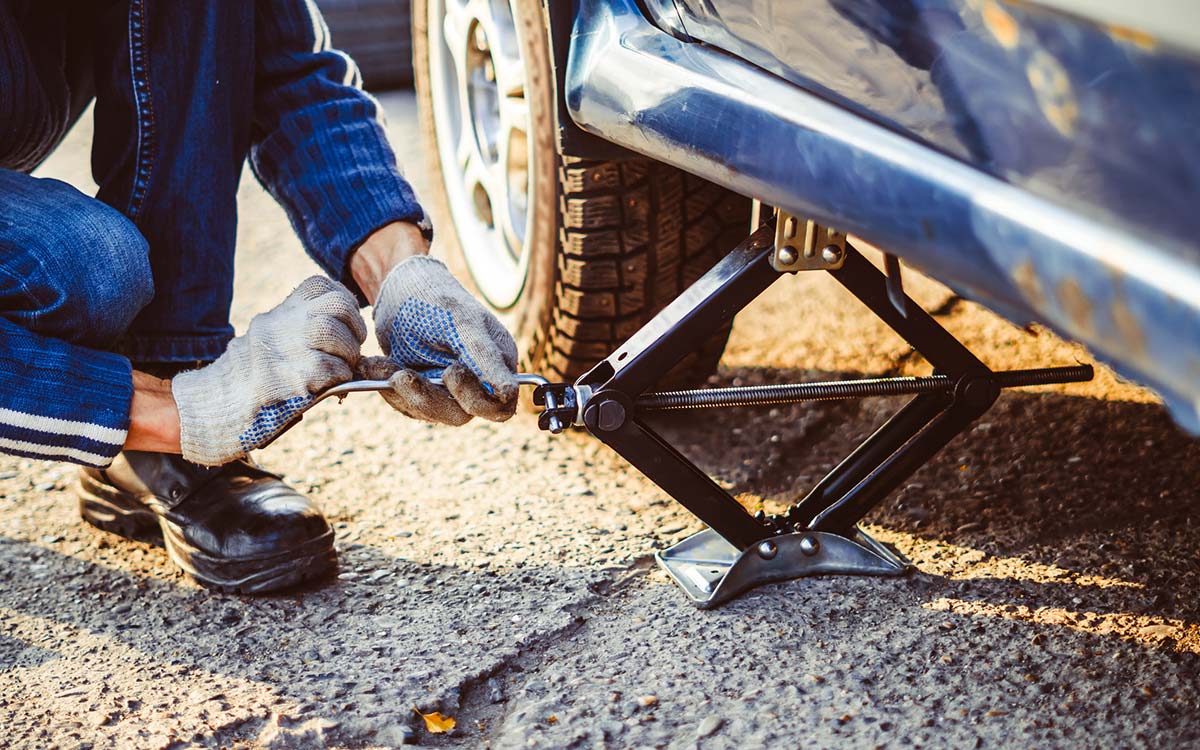 Lifting a car using a car jack.