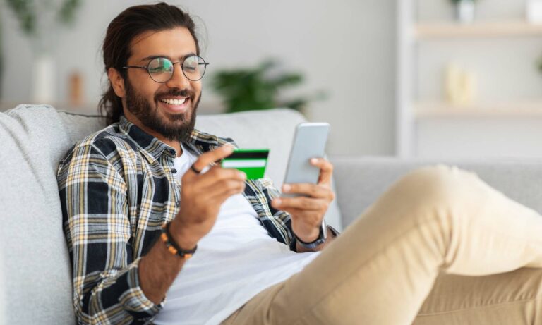 A young man online shopping on his phone.