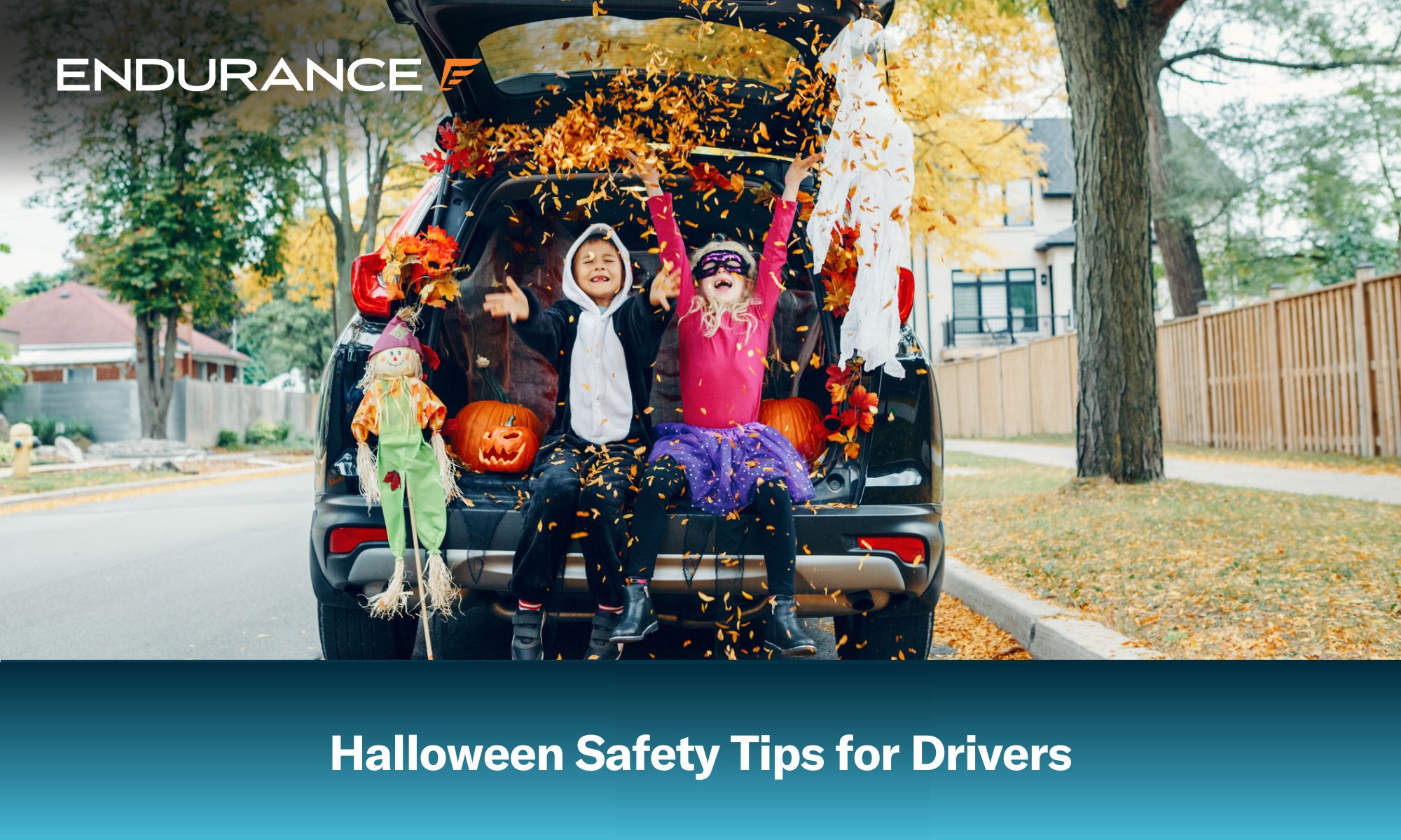Dos niños pequeños disfrazados de Halloween sentados en el maletero de un coche decorado.