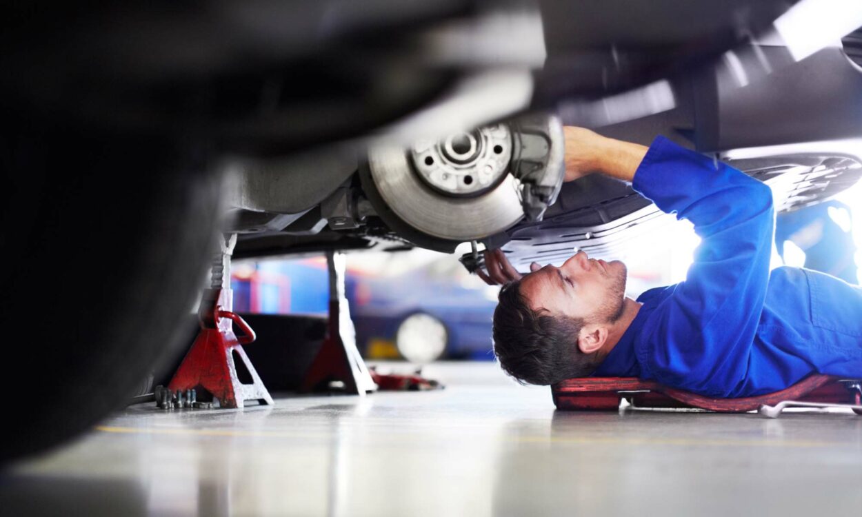 A mechanic working on the brakes of a vehicle.