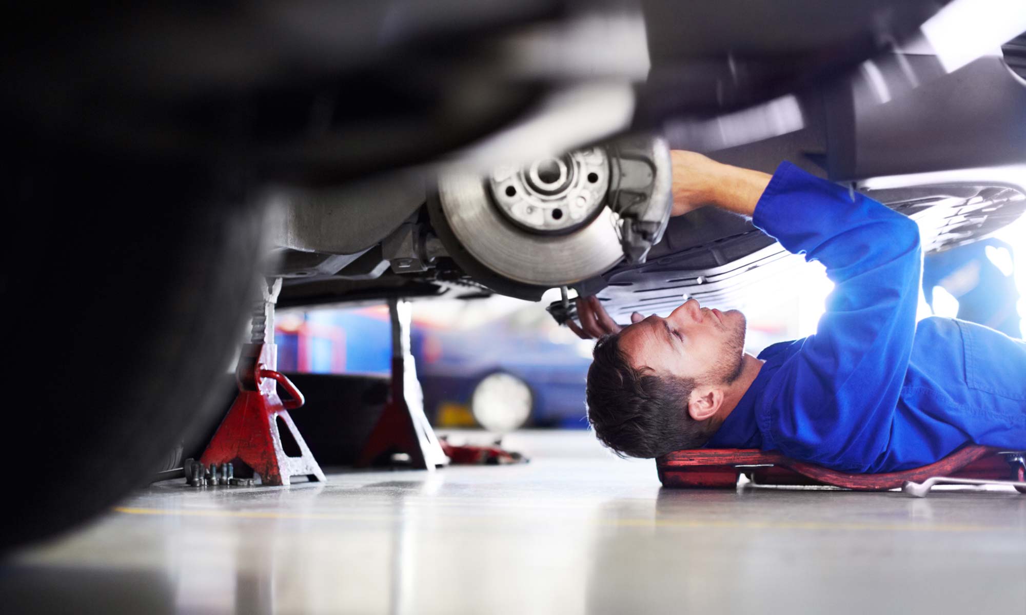 A mechanic working on the brakes of a vehicle.