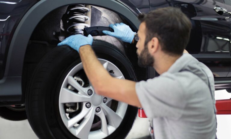 A mechanic inspecting a car's shock absorbers.