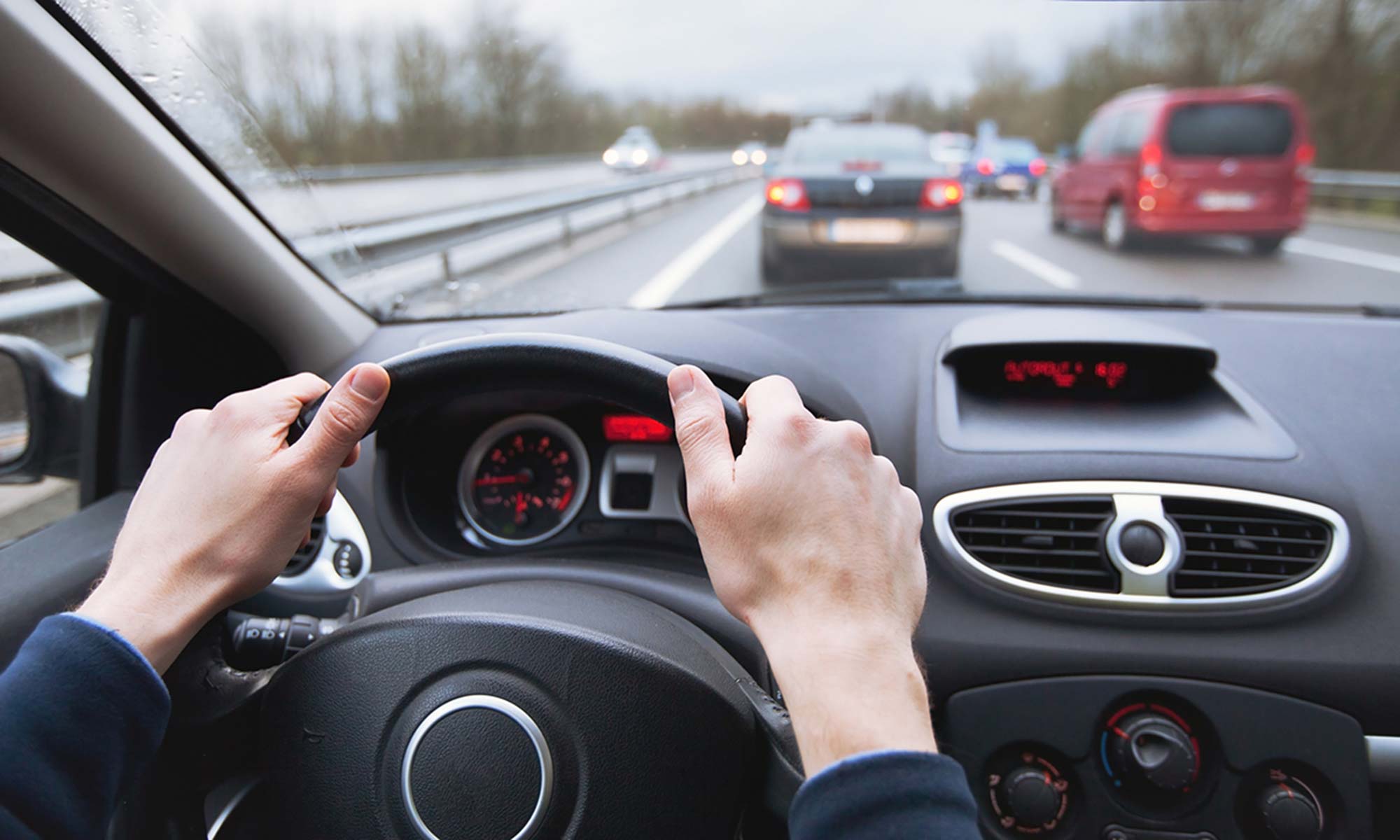 A person's hands on their car's steering wheel.