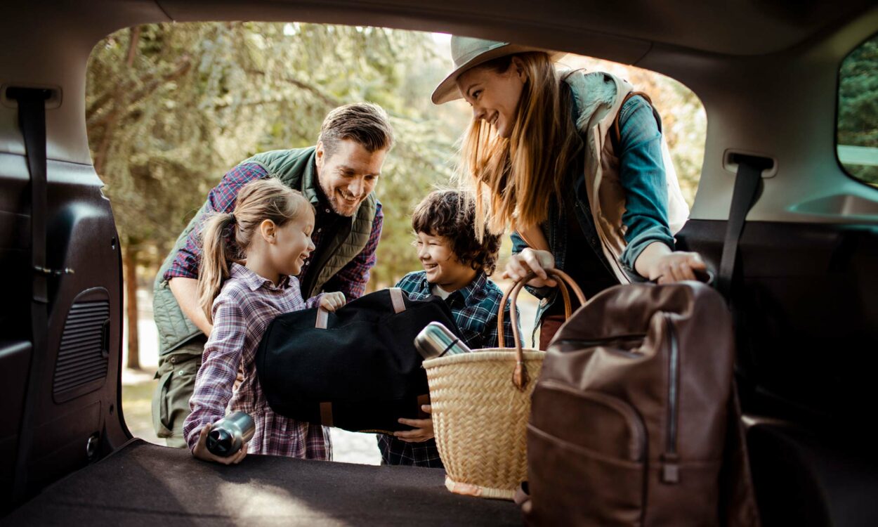 A family packs their car for a road trip.