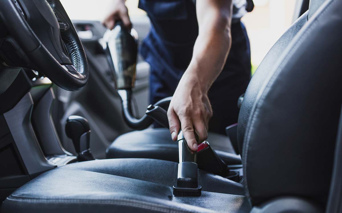 A man vacuuming his driver