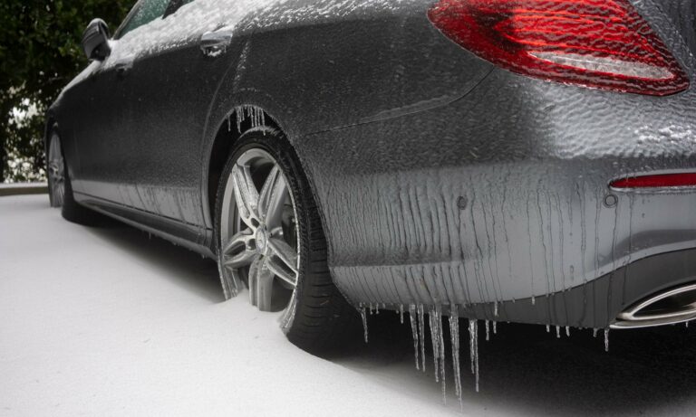 A car parked in the snow and covered in ice.