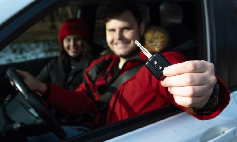 A young couple purchasing a new car in the winter.